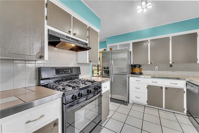 kitchen with light countertops, gas stove, under cabinet range hood, dishwashing machine, and stainless steel fridge with ice dispenser