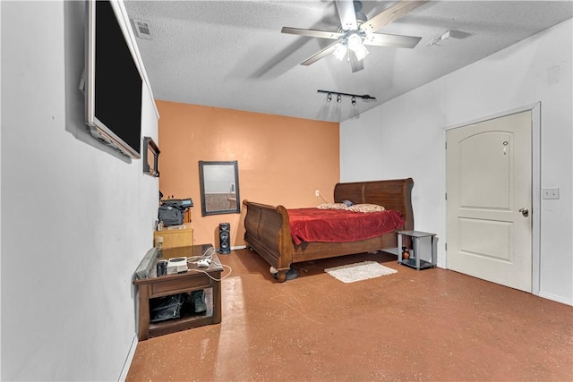 bedroom featuring visible vents, track lighting, finished concrete flooring, and a textured ceiling