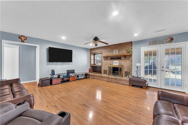 living room featuring recessed lighting, a textured ceiling, ceiling fan, visible vents, and wood finished floors