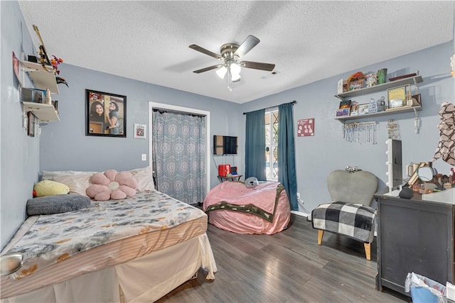 bedroom featuring a textured ceiling, visible vents, wood finished floors, and a ceiling fan