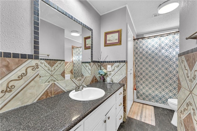 full bath with tile walls, a textured ceiling, a shower with shower curtain, toilet, and vanity