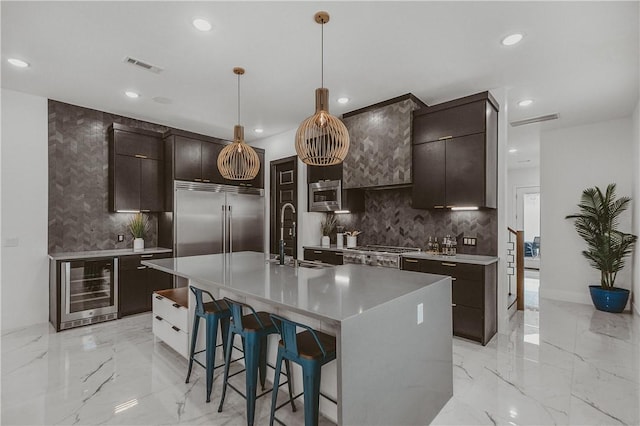 1151 NE Monroe St, Bentonville, AR 72712 - kitchen featuring wine cooler, built in appliances, a sink, light marble finish floors, and decorative backsplash