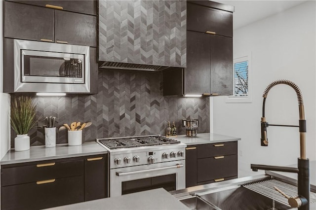 1151 NE Monroe St, Bentonville, AR 72712 - kitchen with stainless steel appliances, wall chimney range hood, decorative backsplash, light countertops, and dark brown cabinets