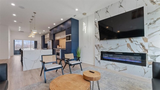 225 SE 7th St, Bentonville, AR 72712 - living room with light wood-style floors, recessed lighting, and a high end fireplace