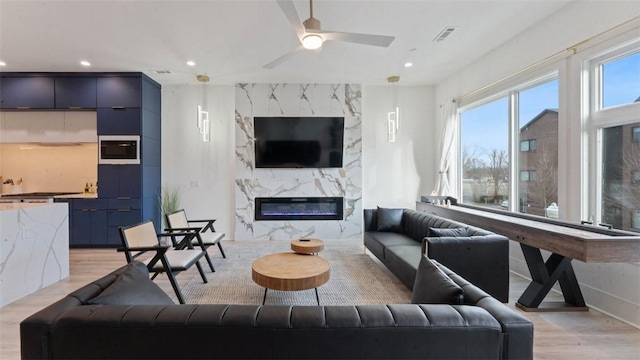 225 SE 7th St, Bentonville, AR 72712 - living room with light wood-style flooring, recessed lighting, a fireplace, ceiling fan, and baseboards