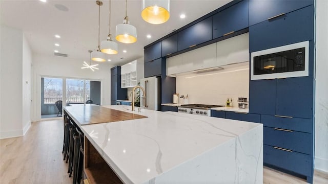225 SE 7th St, Bentonville, AR 72712 - kitchen with built in microwave, modern cabinets, a large island, light wood-type flooring, and recessed lighting
