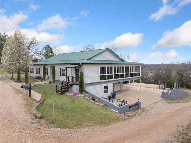 419 Lakeside, Diamond City, AR 72644 - view of front of house featuring a sunroom, metal roof, dirt driveway, an attached garage, and a front yard