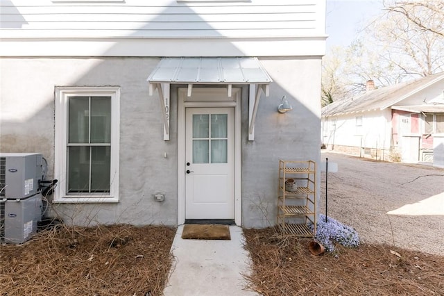 144 N Washington Ave Unit 102, Fayetteville, AR 72701 - doorway to property featuring stucco siding and central AC unit