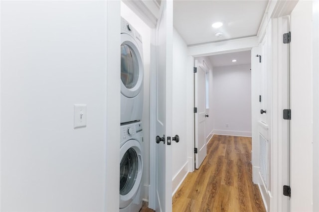 144 N Washington Ave Unit 102, Fayetteville, AR 72701 - washroom with laundry area, baseboards, stacked washing maching and dryer, and light wood-type flooring