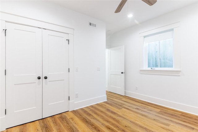 144 N Washington Ave Unit 102, Fayetteville, AR 72701 - unfurnished bedroom with a closet, visible vents, light wood-style flooring, baseboards, and ceiling fan