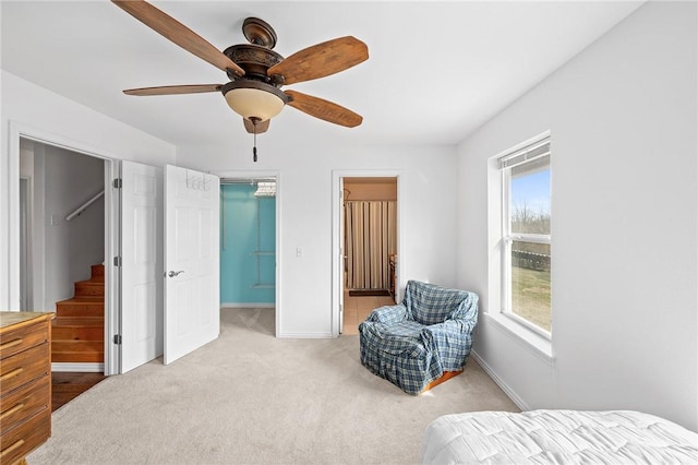 bedroom featuring ensuite bathroom, carpet, baseboards, ceiling fan, and a spacious closet