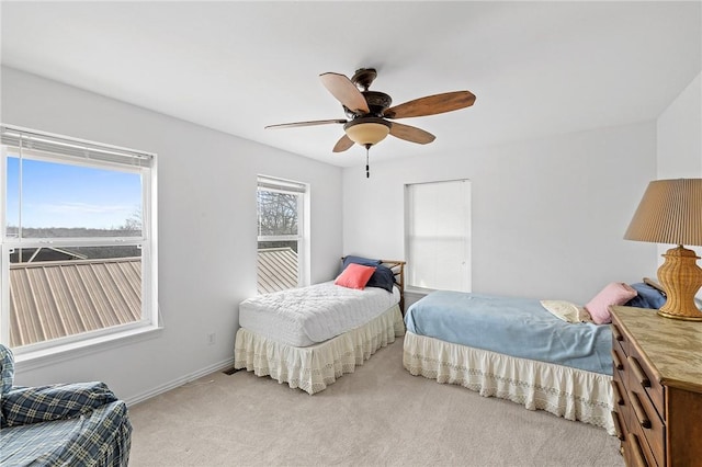 carpeted bedroom featuring baseboards and ceiling fan