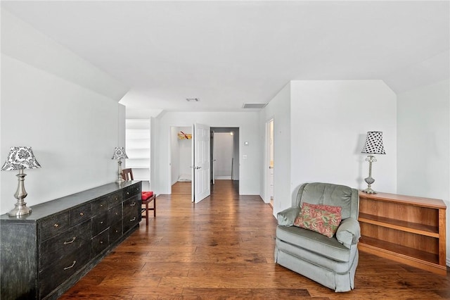living area with baseboards, visible vents, and wood-type flooring