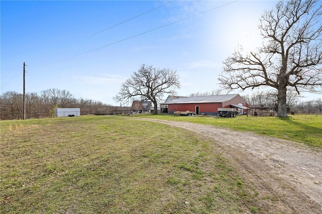 view of yard with dirt driveway and an outdoor structure