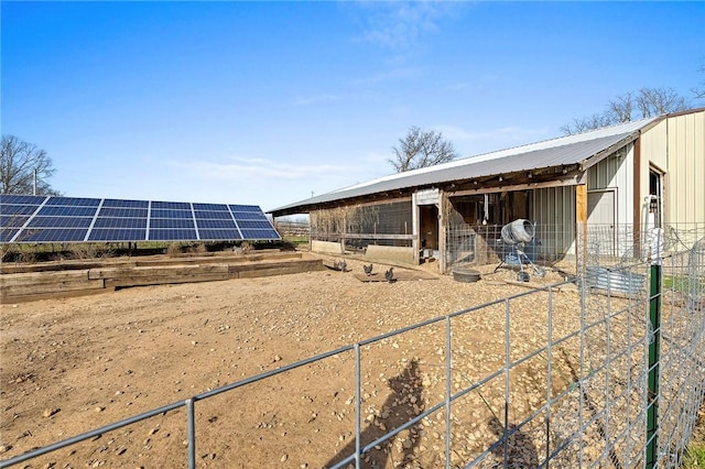 exterior space featuring an outbuilding, an exterior structure, and metal roof