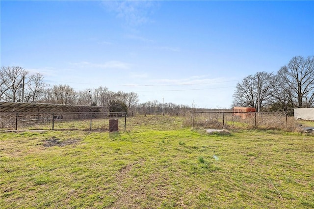 view of yard with fence and a rural view