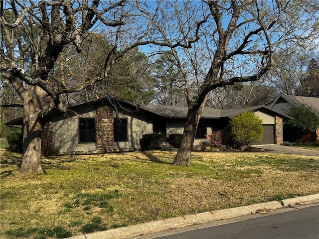 mid-century home with driveway, a front yard, and an attached garage