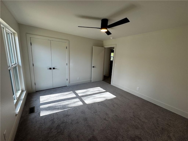 unfurnished bedroom with multiple windows, visible vents, baseboards, and carpet