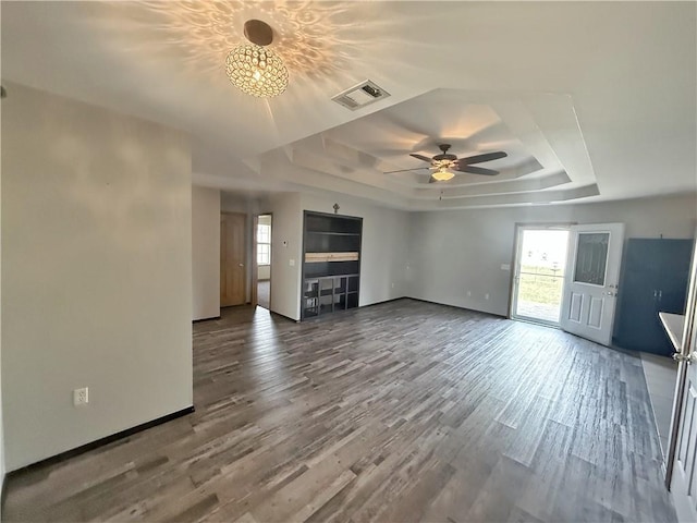 5 Arrowhead Ln, Clarksville, AR 72830 - unfurnished living room with a tray ceiling, healthy amount of natural light, a ceiling fan, and wood finished floors
