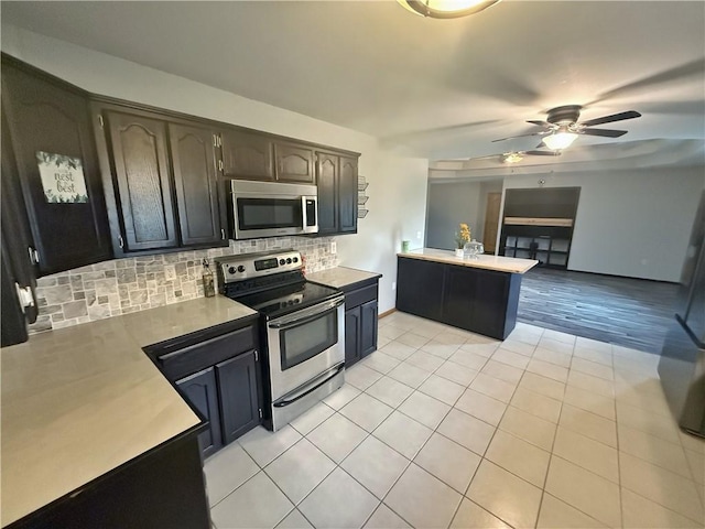 5 Arrowhead Ln, Clarksville, AR 72830 - kitchen featuring appliances with stainless steel finishes, backsplash, light countertops, and a ceiling fan