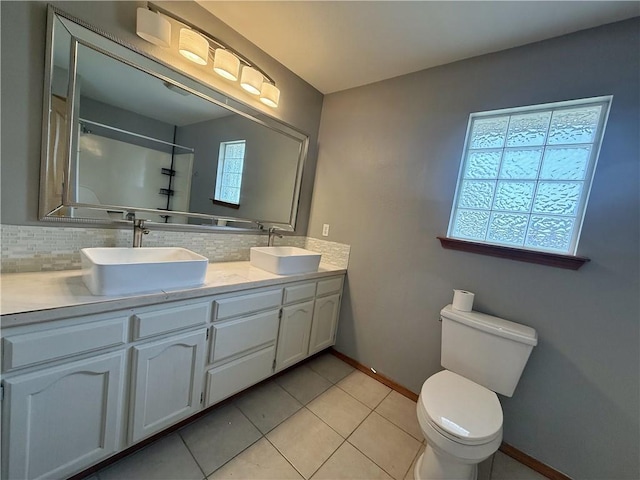 5 Arrowhead Ln, Clarksville, AR 72830 - bathroom with backsplash, toilet, baseboards, double vanity, and tile patterned flooring