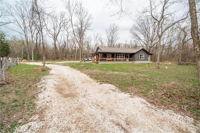 view of front facade with driveway, a front yard, and a porch