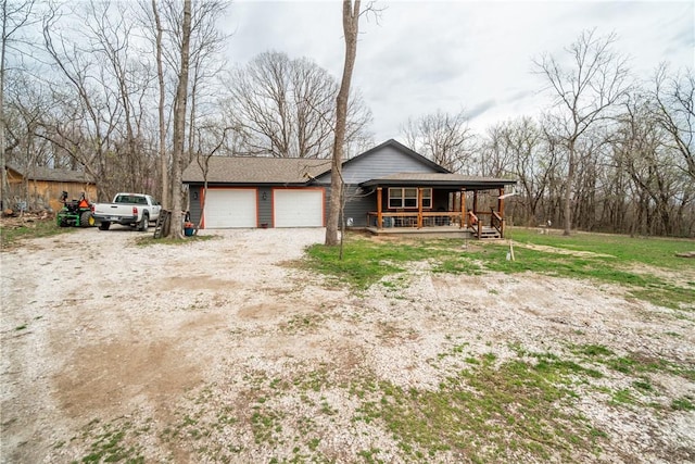 view of front of property featuring a porch, driveway, and an attached garage