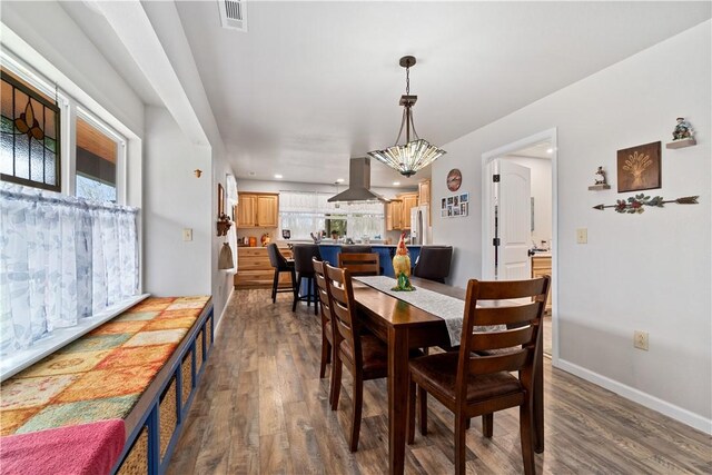 dining room with baseboards, dark wood-style floors, visible vents, and plenty of natural light