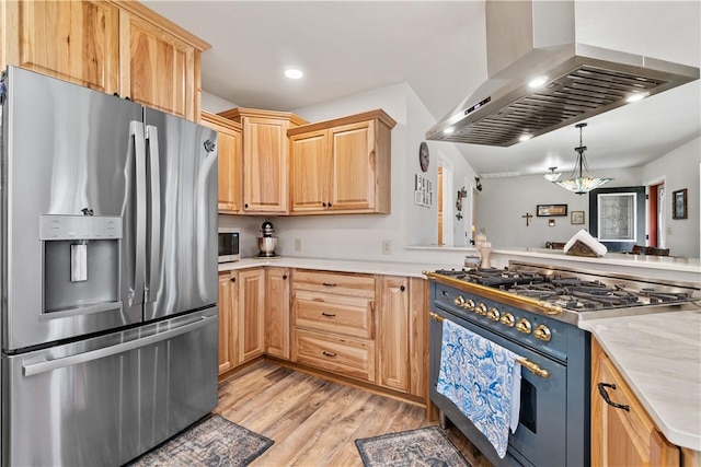 kitchen with wall chimney range hood, light wood finished floors, stainless steel appliances, and light brown cabinets