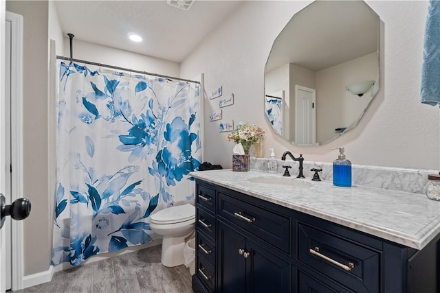 bathroom featuring toilet, vanity, a shower with shower curtain, and wood finished floors