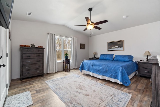 bedroom featuring visible vents, lofted ceiling, ceiling fan, and wood finished floors