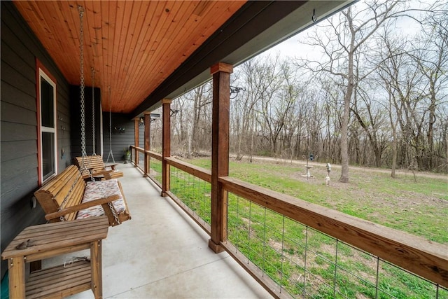 unfurnished sunroom with concrete floors and wooden ceiling