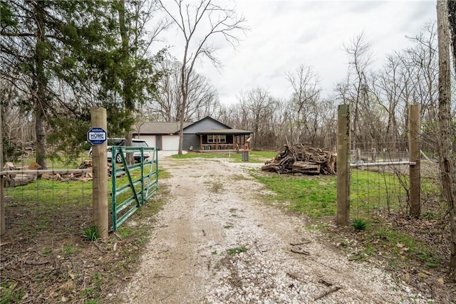 view of street featuring a gated entry, a gate, and driveway