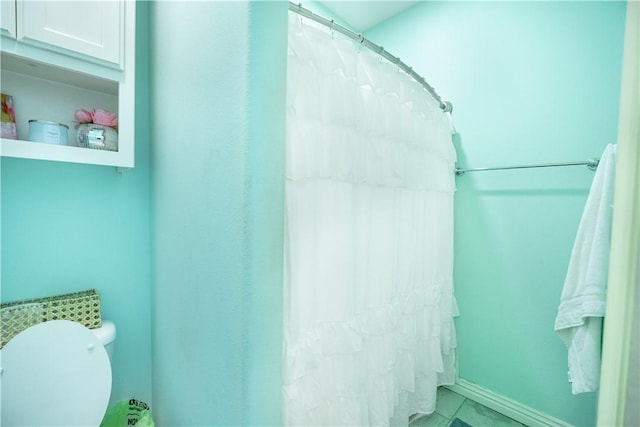 full bathroom featuring toilet, a shower with shower curtain, and tile patterned flooring