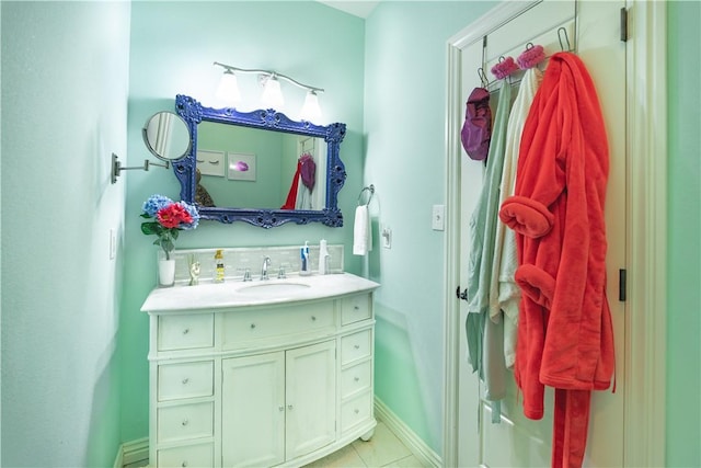 bathroom with baseboards, vanity, and tile patterned flooring