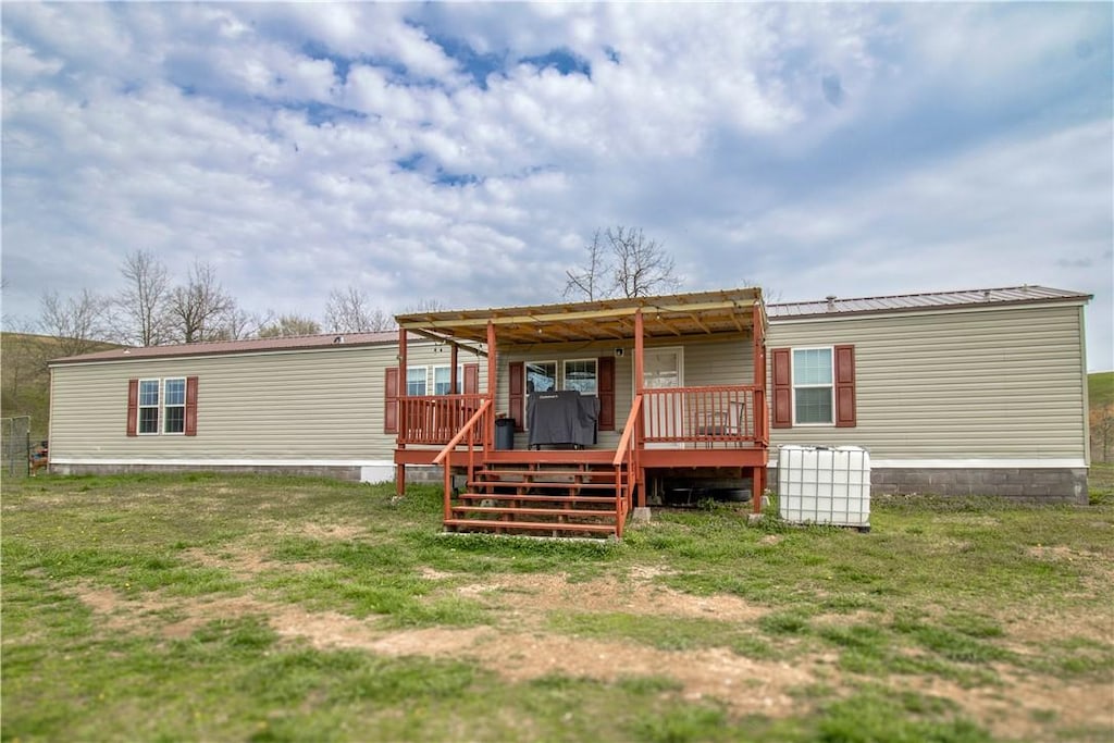 13385 Steward Rd, Siloam Springs, AR 72761 - back of house featuring a lawn, metal roof, and a wooden deck