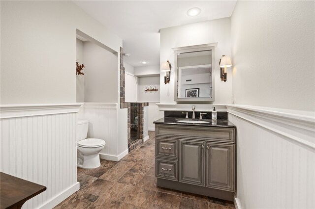617 N Fallin Ave, Fayetteville, AR 72701 - bathroom featuring vanity, toilet, wainscoting, and a shower stall