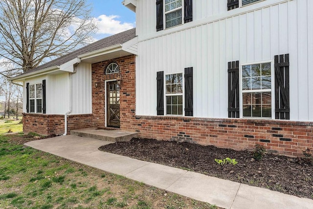 188 Lonestar Rd, Anderson, MO 64831 - doorway to property with board and batten siding, brick siding, and a shingled roof