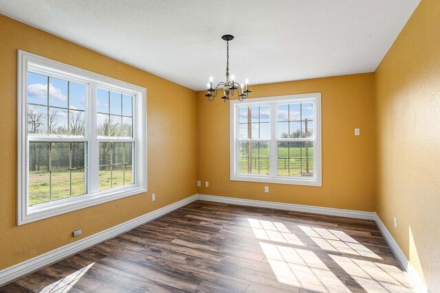 188 Lonestar Rd, Anderson, MO 64831 - empty room with healthy amount of natural light, a chandelier, and dark wood-type flooring