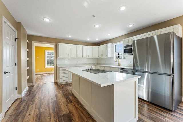 188 Lonestar Rd, Anderson, MO 64831 - kitchen with appliances with stainless steel finishes, dark wood-type flooring, white cabinetry, a kitchen island, and recessed lighting