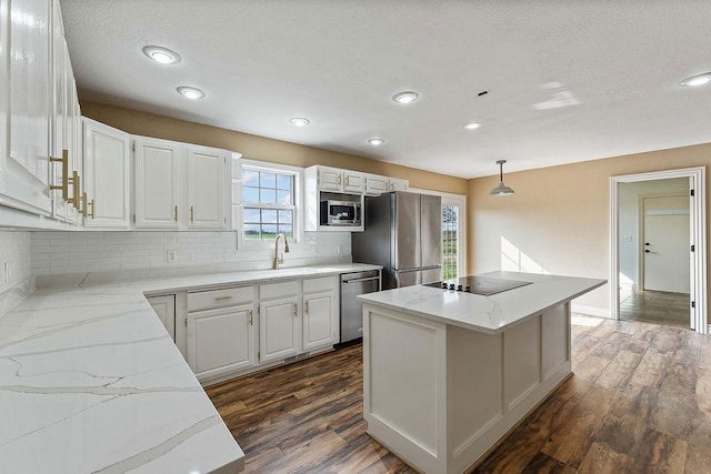 188 Lonestar Rd, Anderson, MO 64831 - kitchen featuring stainless steel appliances, a center island, a sink, decorative backsplash, and white cabinetry
