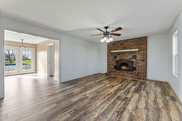188 Lonestar Rd, Anderson, MO 64831 - unfurnished living room featuring wood finished floors, ceiling fan, baseboards, and a fireplace