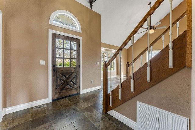 188 Lonestar Rd, Anderson, MO 64831 - entrance foyer featuring stone tile flooring, baseboards, stairway, ceiling fan, and a towering ceiling