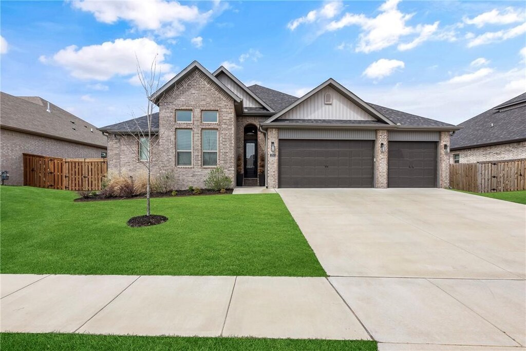 craftsman house featuring fence, a garage, a front yard, brick siding, and driveway
