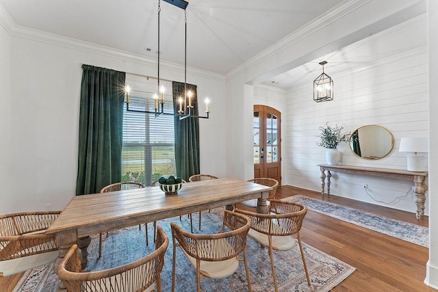 dining space featuring french doors, an inviting chandelier, crown molding, and wood finished floors