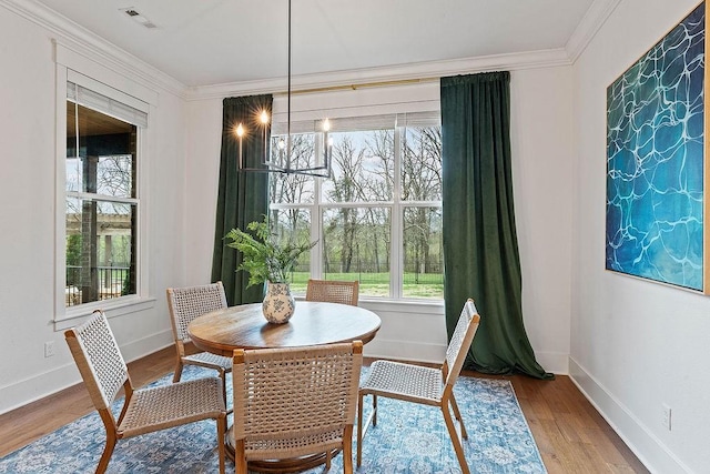 dining area featuring crown molding, wood finished floors, baseboards, and visible vents