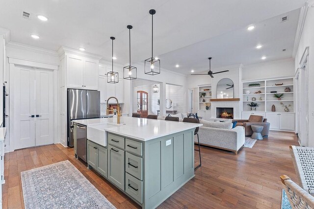 kitchen with a sink, ornamental molding, a ceiling fan, gray cabinets, and hardwood / wood-style floors