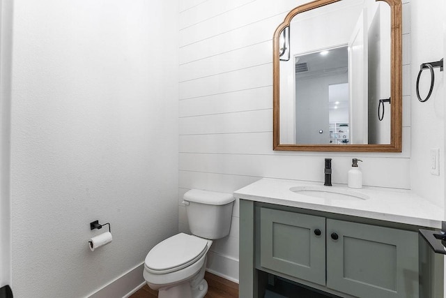 bathroom featuring toilet, vanity, baseboards, and visible vents