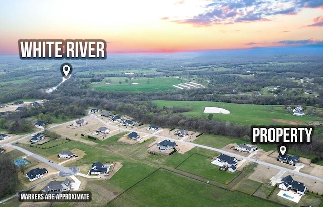 aerial view at dusk featuring a rural view