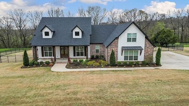 view of front of home featuring roof with shingles, board and batten siding, fence, and a front lawn
